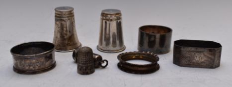 Four various hallmarked silver napkin rings, two white metal shot measures marked 830, Charles