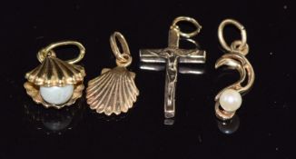 A 9ct gold crucifix, two 9ct gold shell charms, and a 9ct gold pendant, 2.9g
