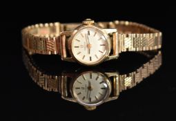 Omega 9ct gold ladies wristwatch with black hands, gold baton markers, silver dial and signed 17