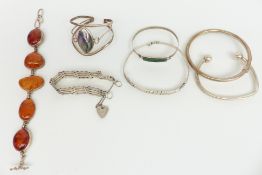 Five silver bangles, a silver gate bracelet and a pressed amber bracelet