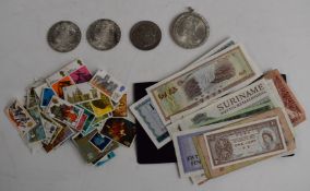 Four silver coins comprising Maria Theresias and 1900 US dollar, with a small collection of