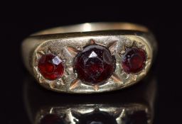 A 9ct gold ring set with three round cut garnets in star settings, 5g, size N
