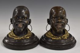 Pair of bronze and gilt metal African head inkwells with hinged lids, on circular bases, bearing