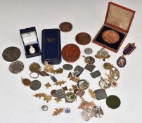 A cased bronze Queen Victoria 1897 commemorative medal, military badges including hallmarked silver,