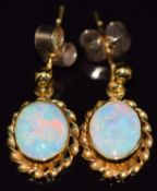 A pair of 9ct gold earrings set with an opal cabochon to each, 2.1g
