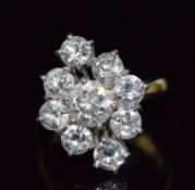 An 18ct gold ring set with a round cut diamond of approximately 1.12ct surrounded by eight further