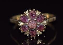 A 9ct gold ring set with a round and oval cut garnets in a cluster, 2.7g, size O