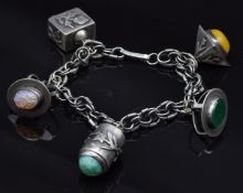 A silver charm bracelet marked 935 with five unusual charms, 52.7g