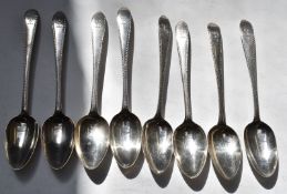 Eight Georgian Irish hallmarked silver dessert spoons with bright cut decoration, four Dublin