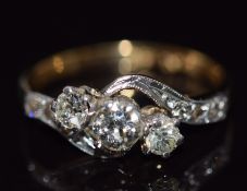 An 18ct gold ring set with three diamonds, the largest diamond approximately 0.25ct, in a platinum