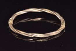 A 9ct gold bangle with twisted ridged decoration, 6.3g