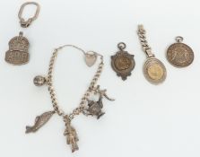 A silver charm bracelet, fob, ARP badge, etc