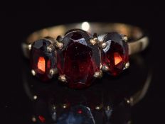 A 9ct gold ring set with three oval cut garnets, 2g, size K