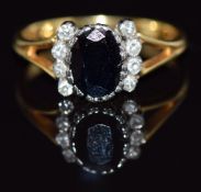 An 18ct gold ring set with an oval cut sapphire and eight diamonds, 3.6g, size O