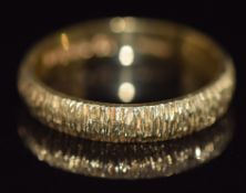 An 18ct gold wedding band with textured detail, 3.3g, size L/M