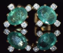 A pair of 9ct gold earrings set with oval cut emeralds, each approximately 1ct and four diamonds