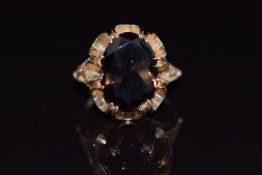 A 9ct gold ring set with an oval cut smoky quartz, 4.8g, size K/L