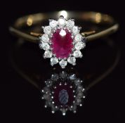 A 9ct gold ring set with an oval cut ruby and diamonds, 2.2g, size Q