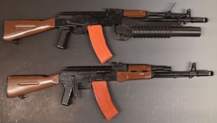 Two airsoft BB guns both in the style of an AK47 machine gun, one with grenade launcher.