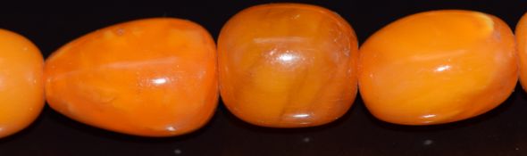 Baltic amber necklace made up of 36 oval beads with a 9ct gold pierced clasp, 47.2g, largest bead