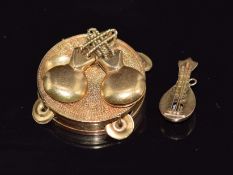 A yellow metal charm in the form of a tambourine and a yellow metal charm in the form of a mandolin,