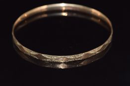 A 9ct gold flapper bangle with engraved decoration, 21.4g