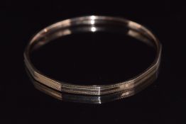 A 9ct rose gold flapper bangle with textured decoration, 9.9g