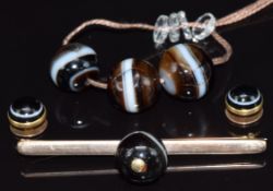Victorian yellow metal brooch set with a banded agate bead, three banded agate beads and two gold