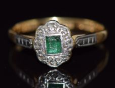 An 18ct gold ring set with an emerald and diamonds in a platinum setting, 2.4g, size N