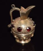 A 9ct gold charm/ pendant in the form of a ewer/ vase set with garnets, 7.5g