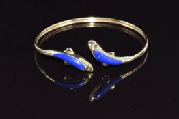 A 14ct gold bangle in the form of two dolphins set with lapis lazuli, 9.4g