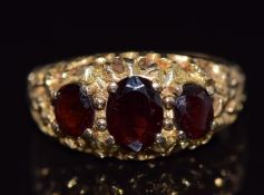 A 9ct gold ring set with three oval cut garnets, 4.2g, size M