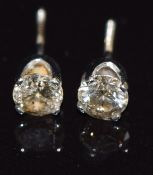 A pair of white metal stud earrings set with a round cut diamond of approximately 0.3ct to each, 0.