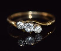 An 18ct gold ring set with three diamonds in a twist setting, 2g, size L
