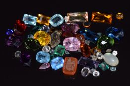 A carved carnelian agate seal depicting a bear reading 'hug me', and a quantity of loose gemstones