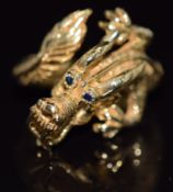 An 18ct gold ring in the form of a dragon with sapphire eyes, 10.7g, size O/P