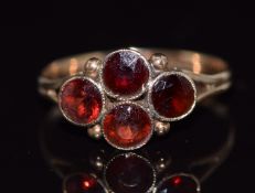 A 9ct gold ring set with four round cut garnets, 1.5g, size O