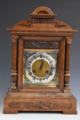 An early 20thC oak cased mantel clock with Junghans two train movement chiming on five bars, Roman