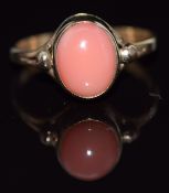 A 9ct gold ring set with an oval coral cabochon, 1.9g, size J/K