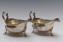 Large pair of George V hallmarked silver gravy or sauce boats with S scroll handles and gadrooned