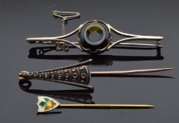 A silver brooch set with amber, a stick pin with yellow metal pin and another silver stick pin