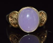 A 14ct gold ring set with a lavender jade cabochon with Chinese character decoration to the