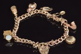 A 9ct gold charm bracelet with six 9ct gold charms including shell, drum, harp, etc, 28.3g