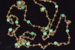 A gold necklace made up of floral links and jadeite beads, 35.6g, 140cm long
