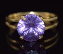 An 18ct gold ring set with a round cut purple sapphire, 4g, size M