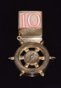 A 9ct gold charm in the form of a compass and a 9ct gold charm set with a 10 shilling note, 4.8g