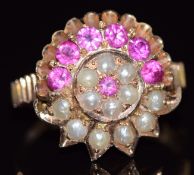 A yellow metal ring set with round cut rubies and seed pearls in a cluster, size K, 4.3g