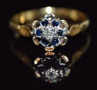 An 18ct gold ring set with a diamond and sapphires, 3.1g, size P