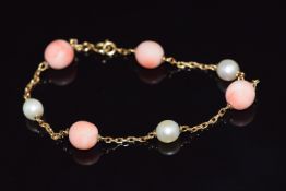 A 9ct gold bracelet set with alternating coral and pearls, 8g