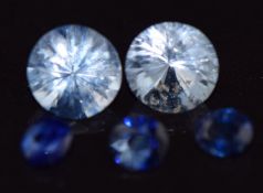 Two loose round cut pale blue sapphires and three further sapphires